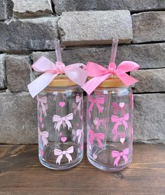 two glass jars with bows and hearts painted on them