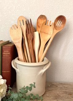 wooden utensils and spoons are sitting in a cup