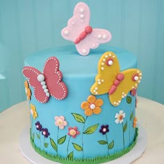 there is a cake decorated with butterflies and flowers on the top of it, along with other decorations