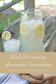 a pitcher of lemonade with ice and sliced lemons next to it on a wooden table