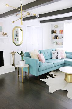 a living room with blue couches and white rugs on the hardwood flooring