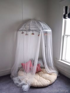 a canopy bed in the corner of a room with two pillows on top of it