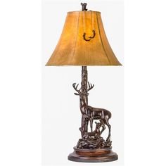 a lamp that is on top of a wooden base with a deer and antelope