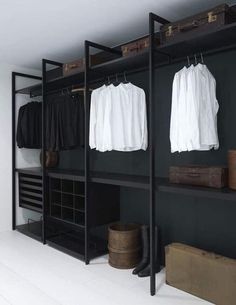 an open closet with clothes hanging on shelves