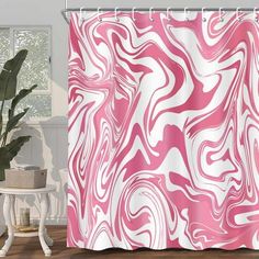 a shower curtain with pink and white swirls on it in front of a window