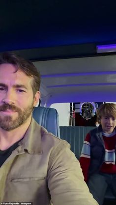 a man with a beard is sitting in a bus and looking up at the camera