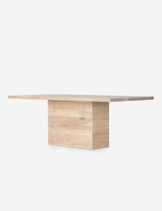 a wooden table sitting on top of a white wall