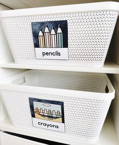 two white baskets with pencils on them are sitting next to each other in the closet