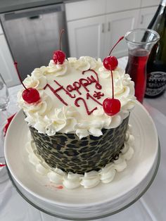 a birthday cake with white frosting and cherries