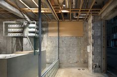 the inside of a building with concrete walls and exposed ceilinging, including electrical equipment