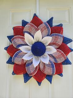 a red, white and blue flower made out of burlocks on a door