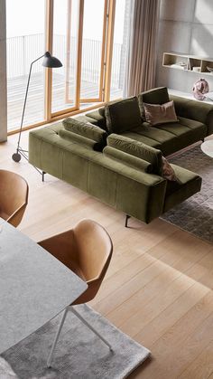 a living room filled with furniture next to a large glass window and wooden flooring