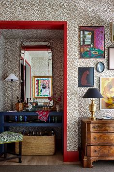 a living room filled with furniture and pictures on the wall next to a dresser under a mirror