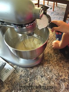 a person using a mixer on top of a counter