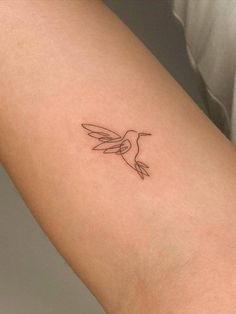 a small hummingbird tattoo on the arm