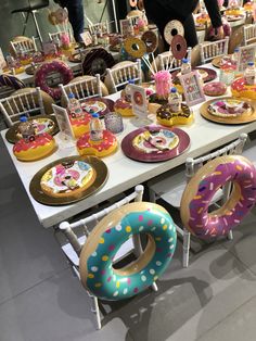 a table topped with lots of donuts covered in frosting and sprinkles