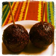 two chocolate covered donuts on a white plate