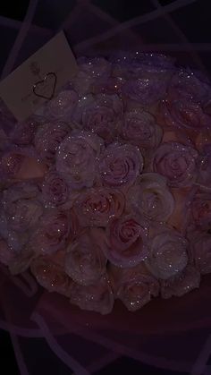 a bouquet of pink roses with water droplets on it and a card in the middle