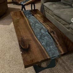 a coffee table made out of wood and glass with water running down the center piece