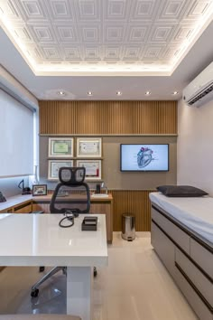 a room with a bed, desk and television on the wall next to each other