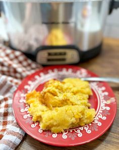 a red plate topped with mashed potatoes next to an instant pressure cooker in the background