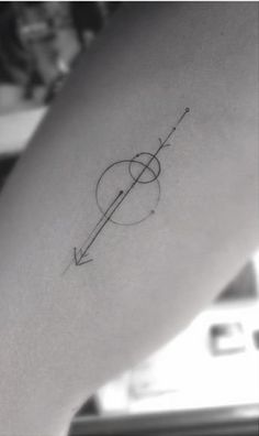 a small tattoo on the arm of a woman with an arrow and circle in it