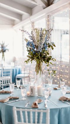 a blue table cloth topped with a vase filled with flowers