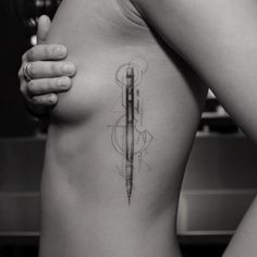 a woman with a tattoo on her stomach holding a knife in one hand and looking at the other