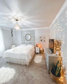 a bedroom with white bedding and lights on the walls