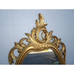 an ornate gold mirror against a blue wall