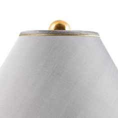 a lamp that is on top of a white surface with a gold trim around it