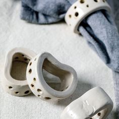 two white ceramic shoes sitting on top of a bed