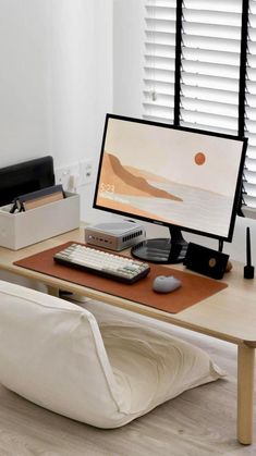 a computer desk with a keyboard, mouse and monitor on it in front of a window