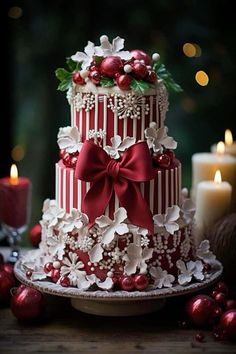 a three tiered cake decorated with red and white flowers, holly wreaths and bows