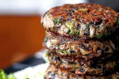 three burgers stacked on top of each other with lettuce in the foreground