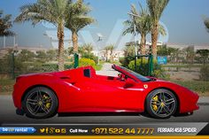 a red sports car parked in front of palm trees