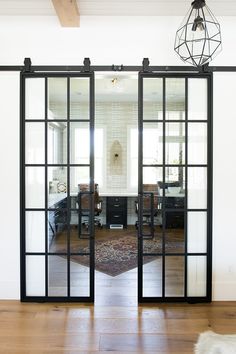 an open glass sliding door in the middle of a room with wood floors and white walls