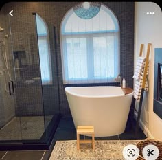 a bathroom with a bathtub, rug and window in the shower stall is shown