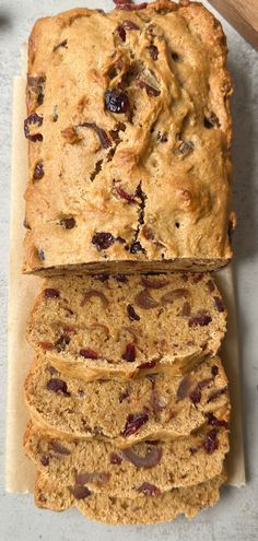 a loaf of fruit bread sitting on top of a cutting board