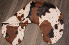 a brown and white cow print neck pillow