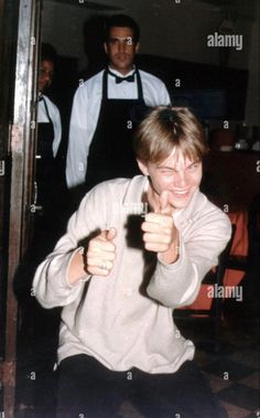 a woman pointing her finger at the camera while another man looks on - stock image