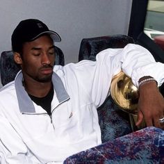 a man sitting on top of a couch next to a hat