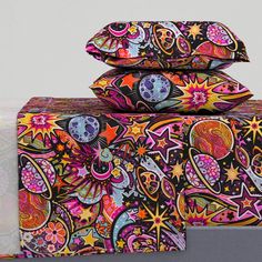 three pillows are stacked on top of each other with colorful designs and stars all over them