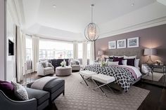 a large bedroom with gray and white decor