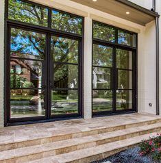 a house with large windows and steps leading up to the front door