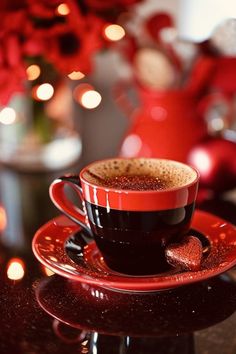 a cup of coffee sitting on top of a saucer next to a christmas tree