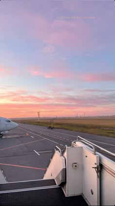 an airplane is parked on the tarmac at sunset with its door open to let passengers board