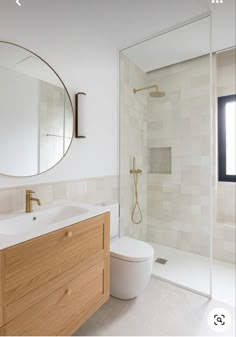 a bathroom with a sink, toilet and shower stall in the background is a large mirror