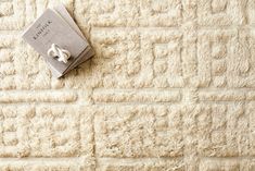 a book laying on top of a white rug