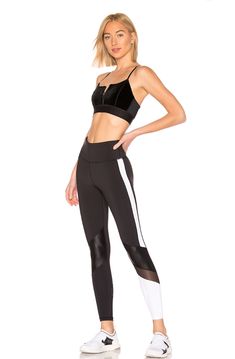 a woman in black sports bra top and leggings with white stripes on the side